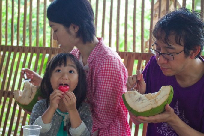 カカオ農園ツアーで果物を食べている家族の写真