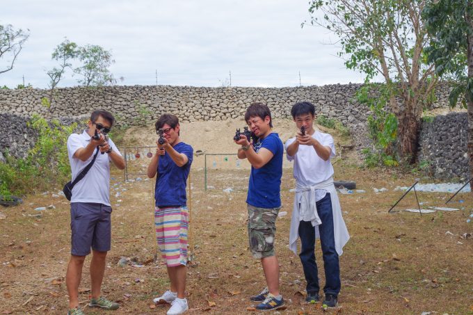 実弾射撃場で銃を向ける男性4人